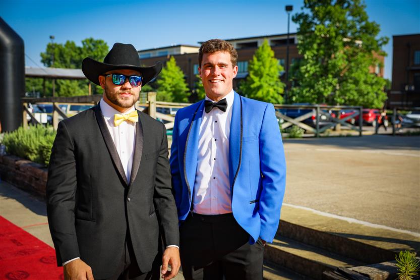 Two student-athletes stand on the red carpet